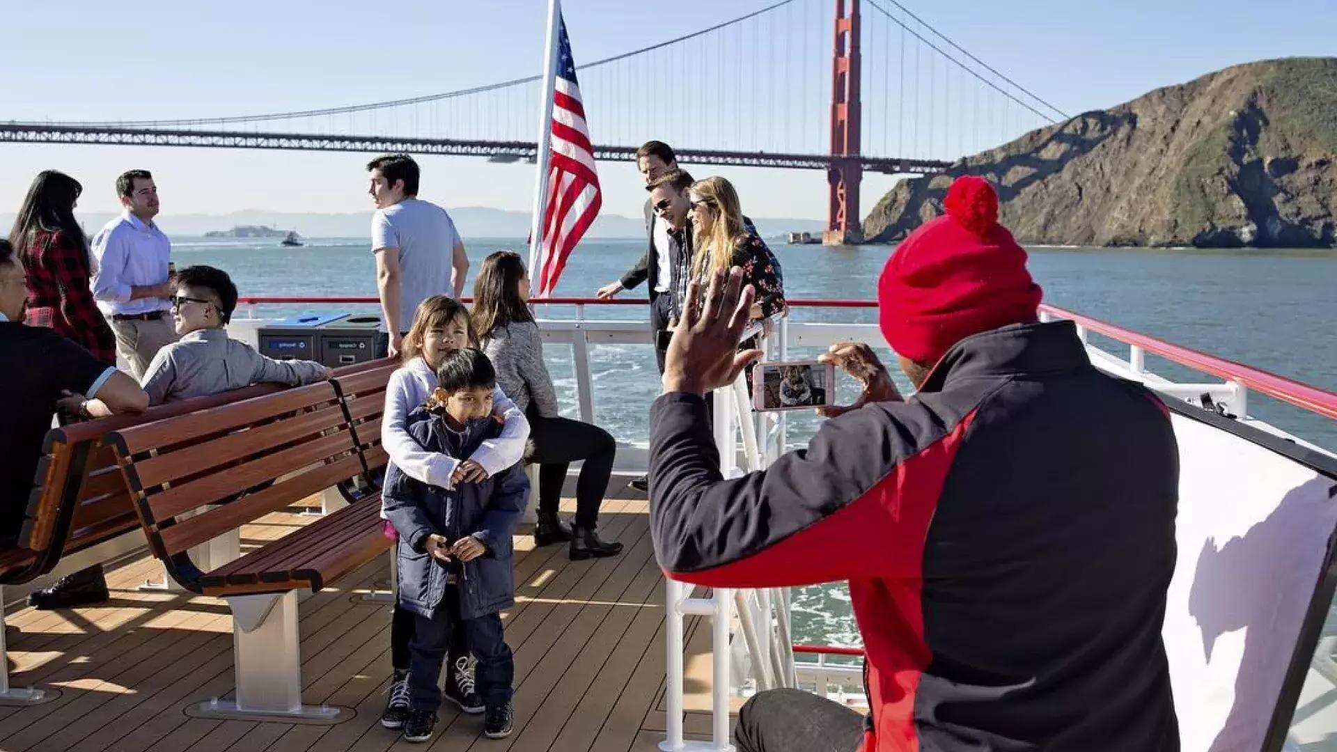 一家人在海湾上乘船游览，经过金门大桥.